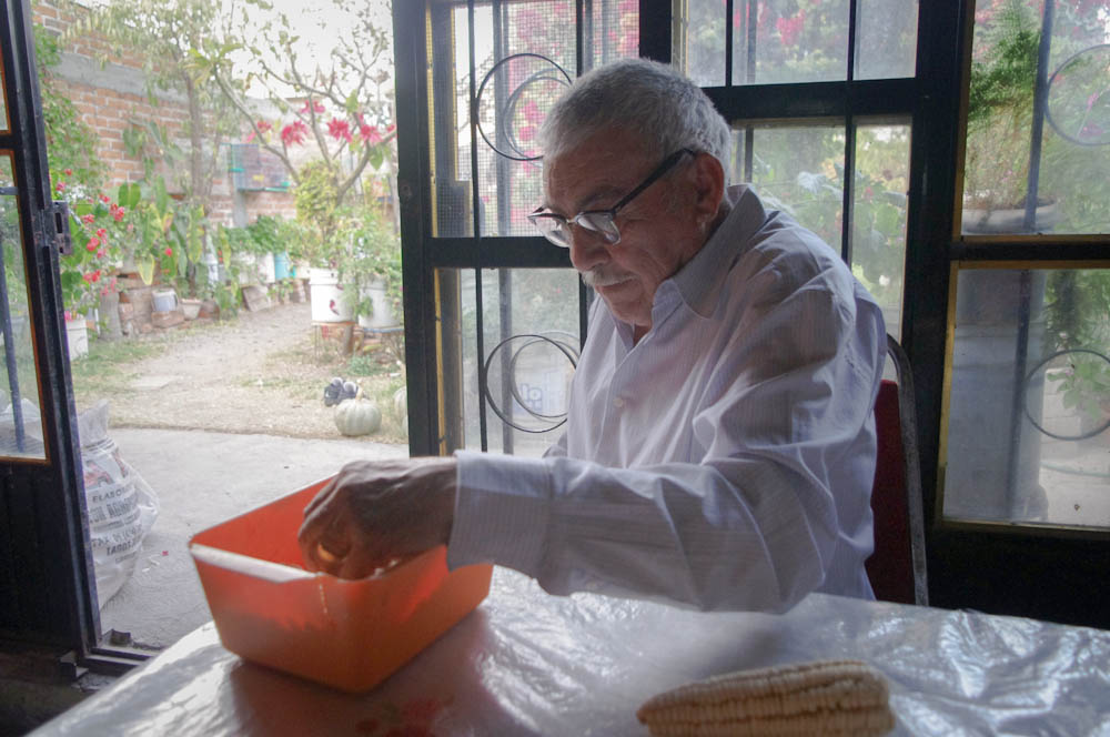 Tio Miguel, shelling dry corn for his chickens