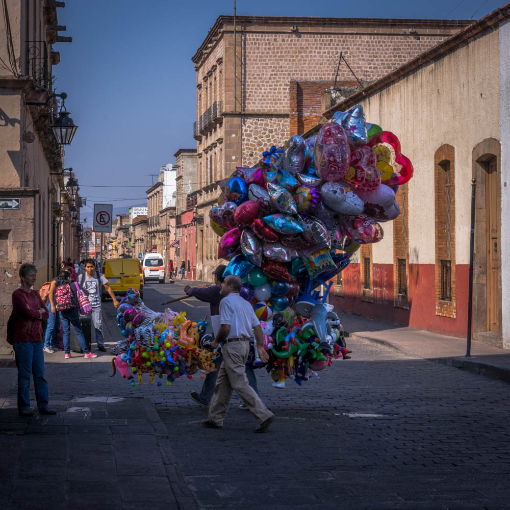 A balloon vendor heads out with his stock for another day...