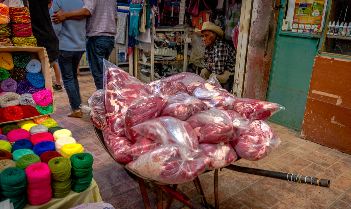 Bags of Pork with Skeins of Yarn in the Mercado.